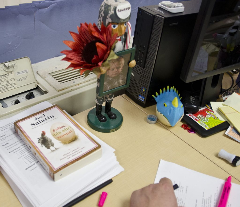 A book and a family photograph rest on the desk of a veteran who served before returning to civilian life as a farmer.